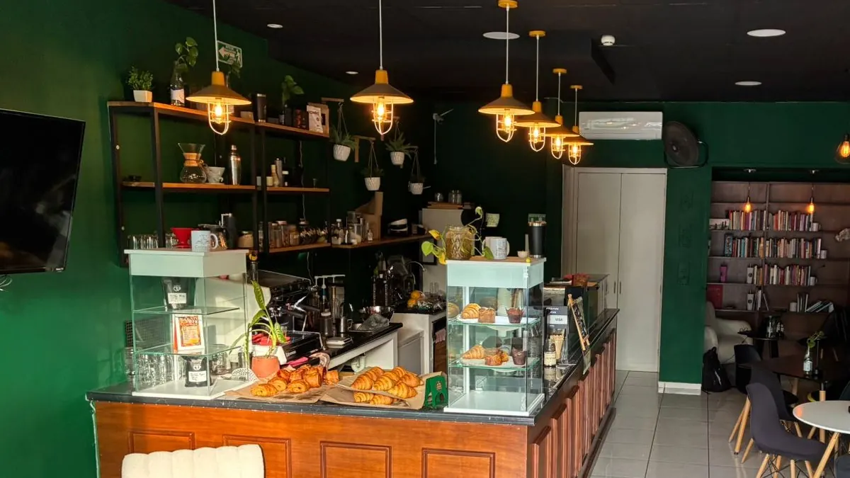 Vista de la barra de Cofradía con los croissants y la panadería del día en la vitrina, bajo las lámparas colgantes